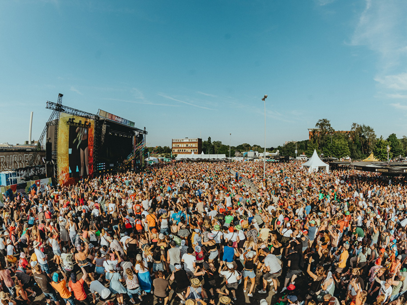 Große Menschenmenge vor der Bühne bei der Olé Sommerparty unter blauem Himmel