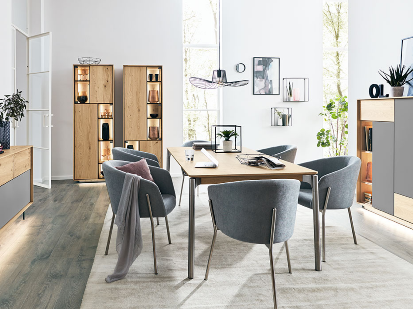 Moderner Essbereich mit einem Holztisch und Stühlen, umgeben von stilvollem Dekor und natürlichem Licht.
