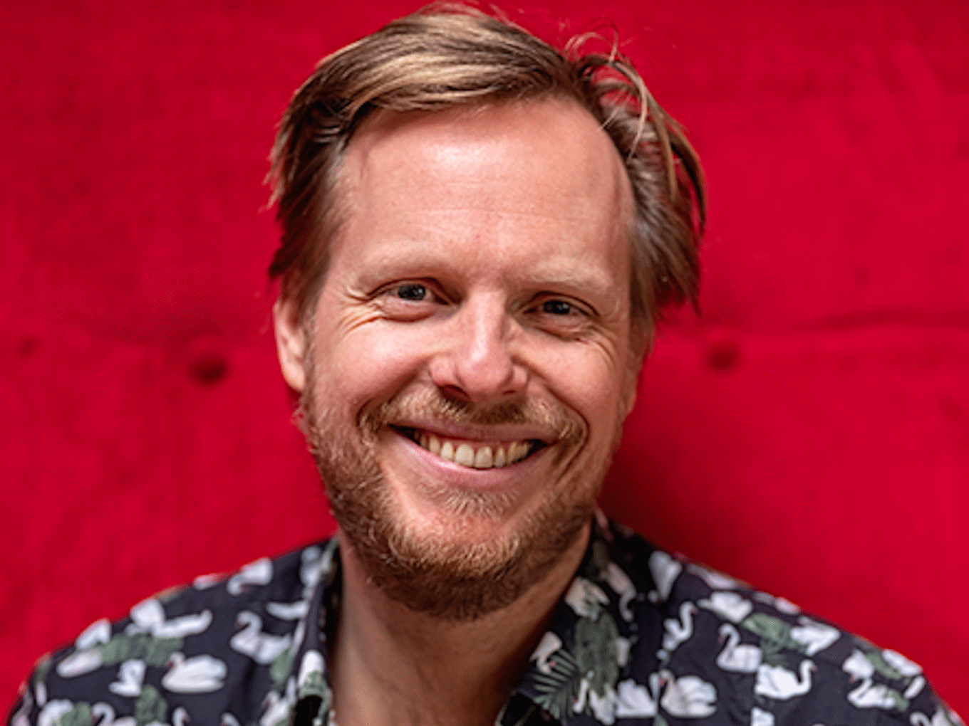 Portraitfoto von Patrick Nederkoorn vor rotem Hintergrund