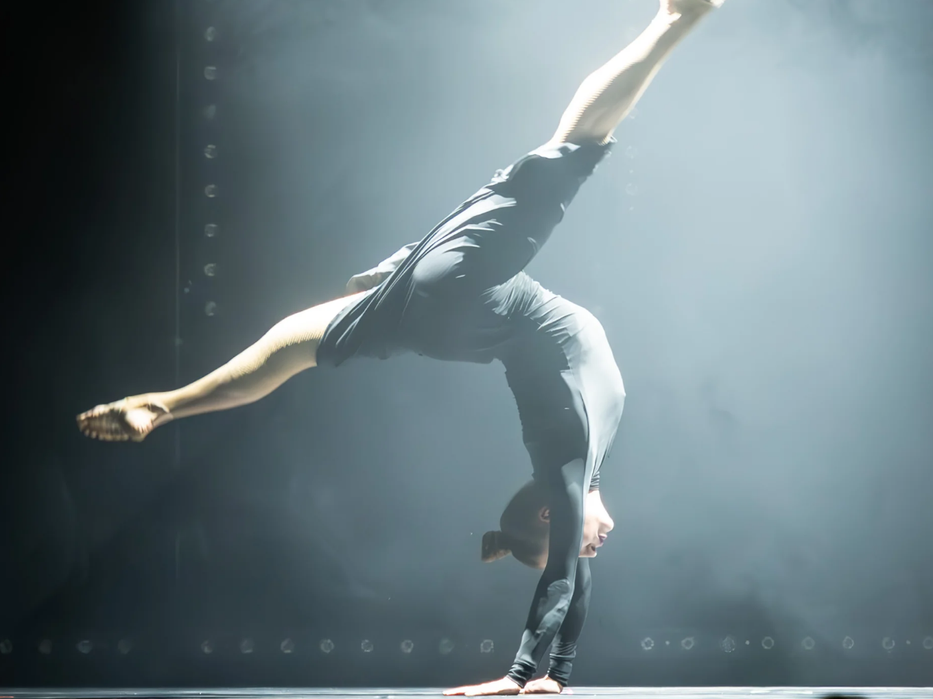 Akrobatin im Handstand auf der Varieté-Bühne