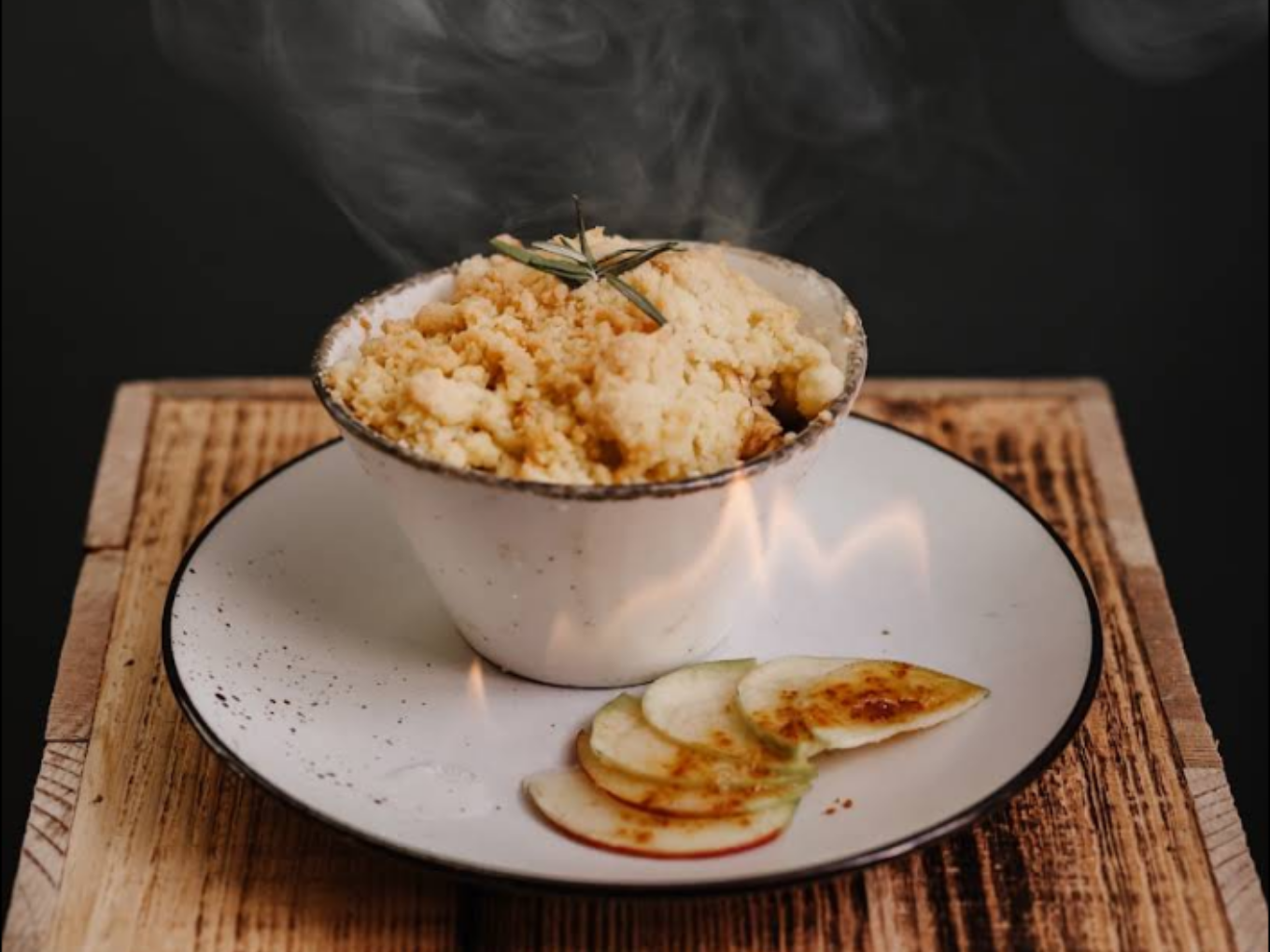 Dampfendes Gericht mit goldbrauner Kruste und Apfelscheiben, serviert im Restaurant Am Jäger.