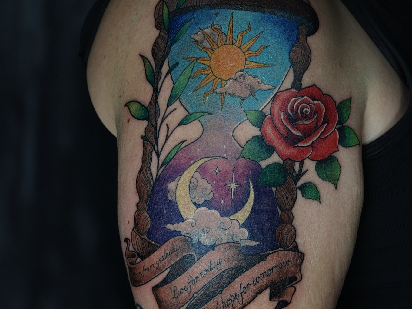 Farbiges Tattoo mit Sanduhr, Sonne, Mond, Wolken und roter Rose