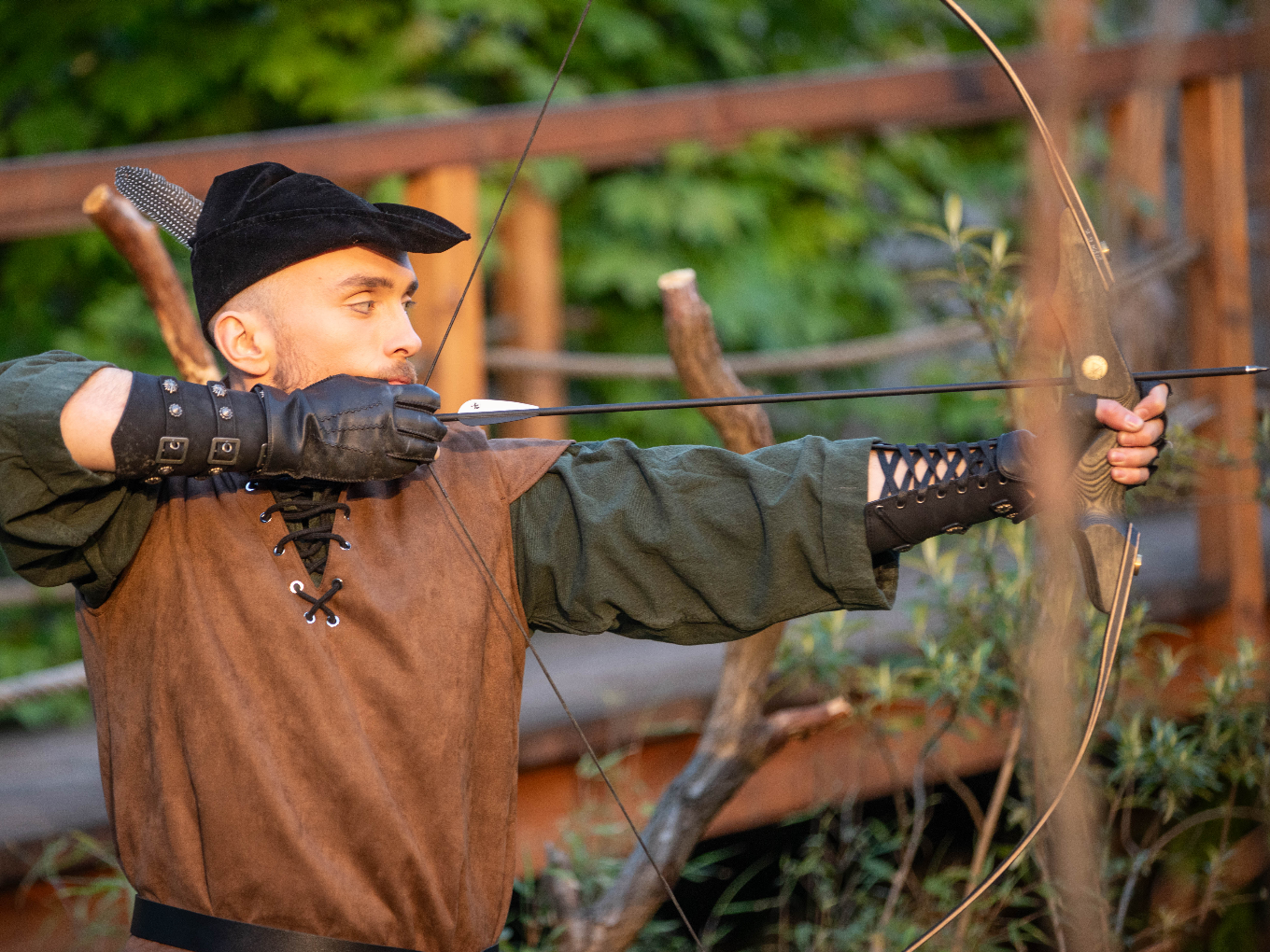 Robin Hood zielt bei einer Freilichtaufführung mit Pfeil und Bogen.