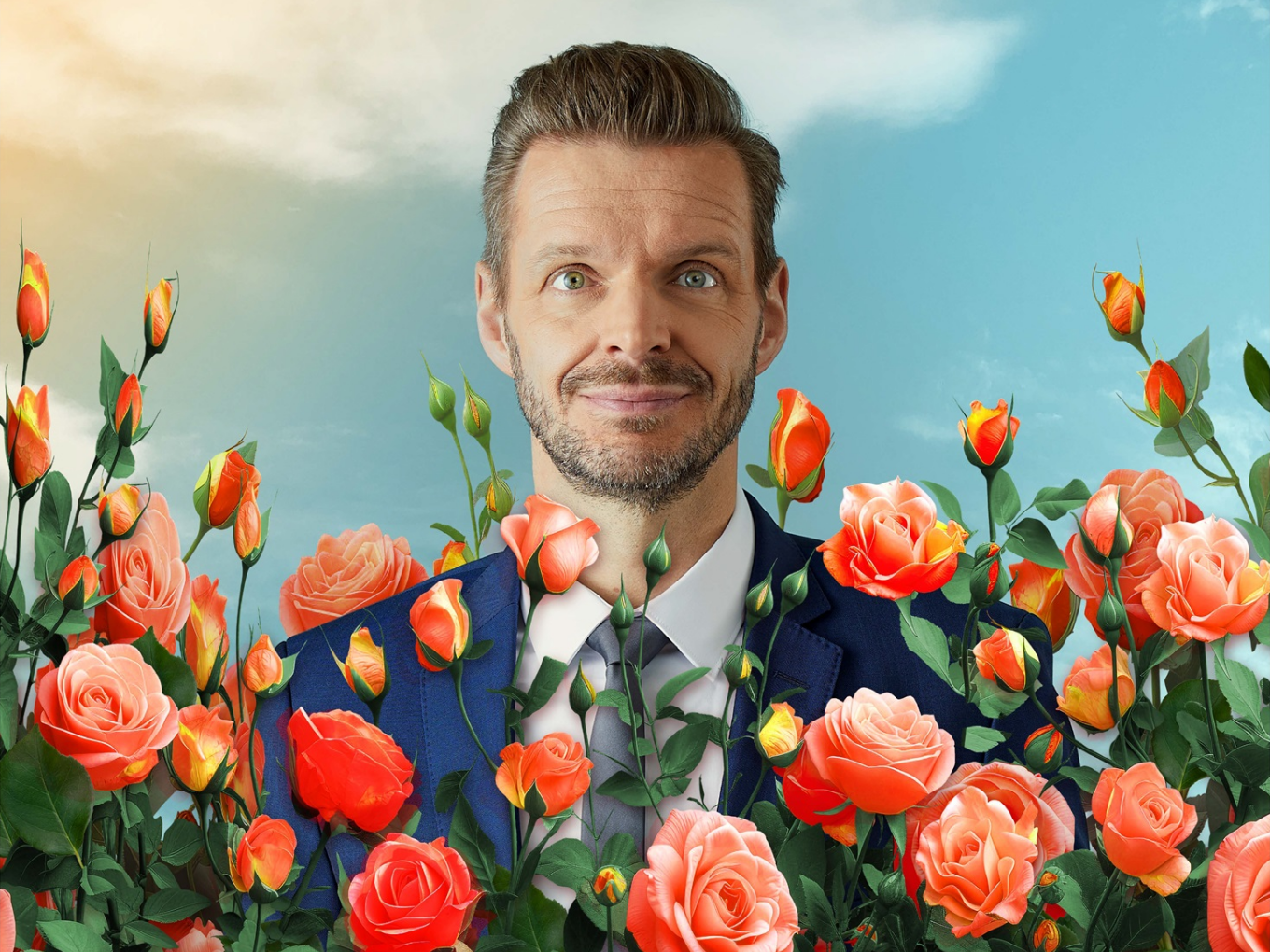 Kabarettist Florian Schroeder im Anzug zwischen zahlreichen Rosen
