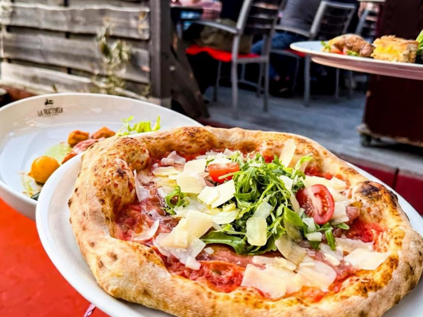 Italienische Pizza mit Rucola, Tomaten, Schinken und Parmesan