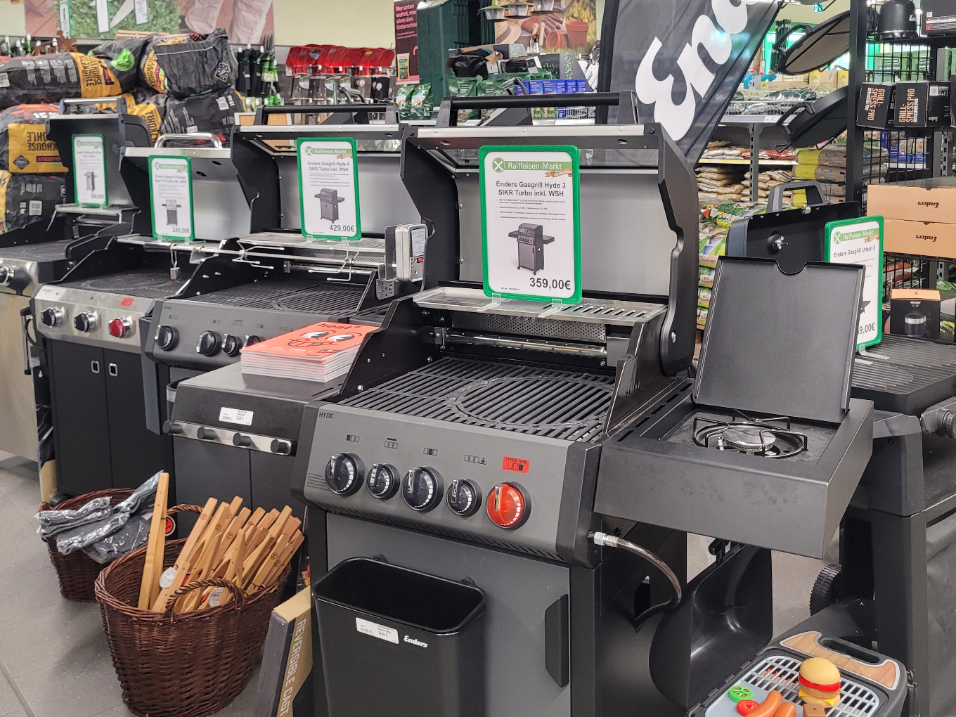Auswahl an Gasgrills im Raiffeisen-Markt, verschiedene Modelle und Zubehör.