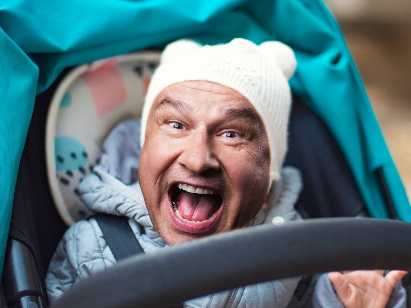 Lars Reichow mit weißer Mütze in einem Kinderwagen